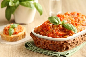 Eggplant salad (caviar) in bowl with basil leaves